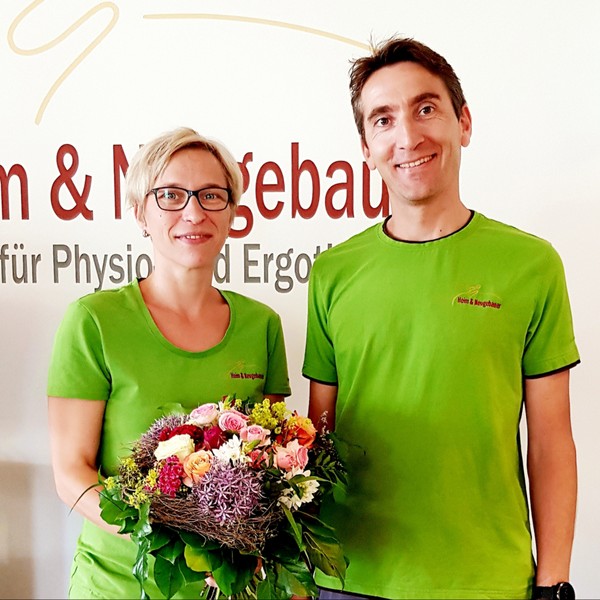 Praxisinhaber Frank Heim gratuliert Physiotherapeutin Andrea Schocker mit einem Blumenstraß zum 10 jährigen Praxisjubiläum