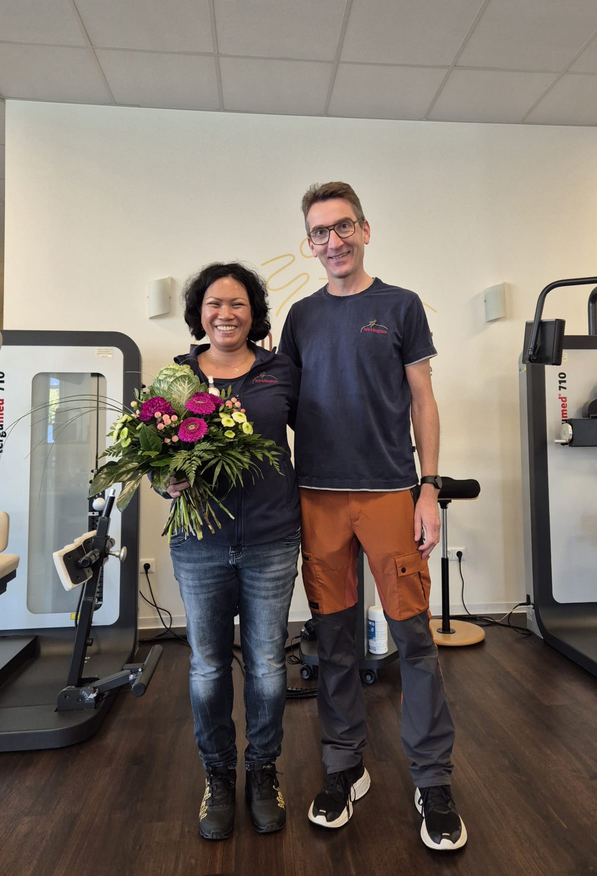 Blumenübergabe von Frank Heim an Physiotherapeutin Laura Yayuk Clasani